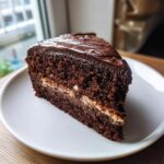 A slice of delicious Guinness Chocolate Cake with Irish Buttercream on a white plate.