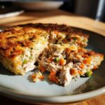 Close-up of a slice of homemade cat birthday cake with chicken and vegetables.