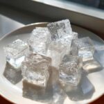 Close-up of clear ice cubes on a white plate, perfect for Homemade Cat Ice Treats.