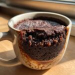 Close-up of a warm Microwave Fudgy Brownie for One in a mug, ready to eat.
