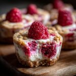 Close-up of a delicious Raspberry Cream Cheese Bite with fresh raspberry topping on a wooden board.