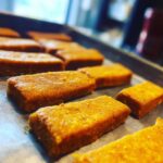 Close-up of freshly baked Salmon & Sweet Potato Cat Treats on a baking sheet.