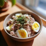 Close-up of a bowl filled with Tuna & Egg Cat Meal, including tuna, egg slices, and herbs.