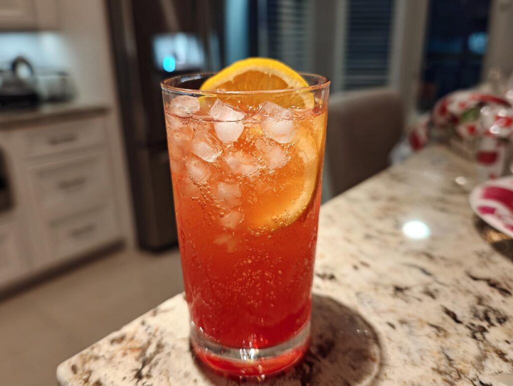 A vibrant Beach Cocktail recipe with ice and an orange slice, perfect for summer.