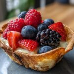 Close-up of a Berrylicious Cheesecake Taco filled with cheesecake and topped with fresh berries.