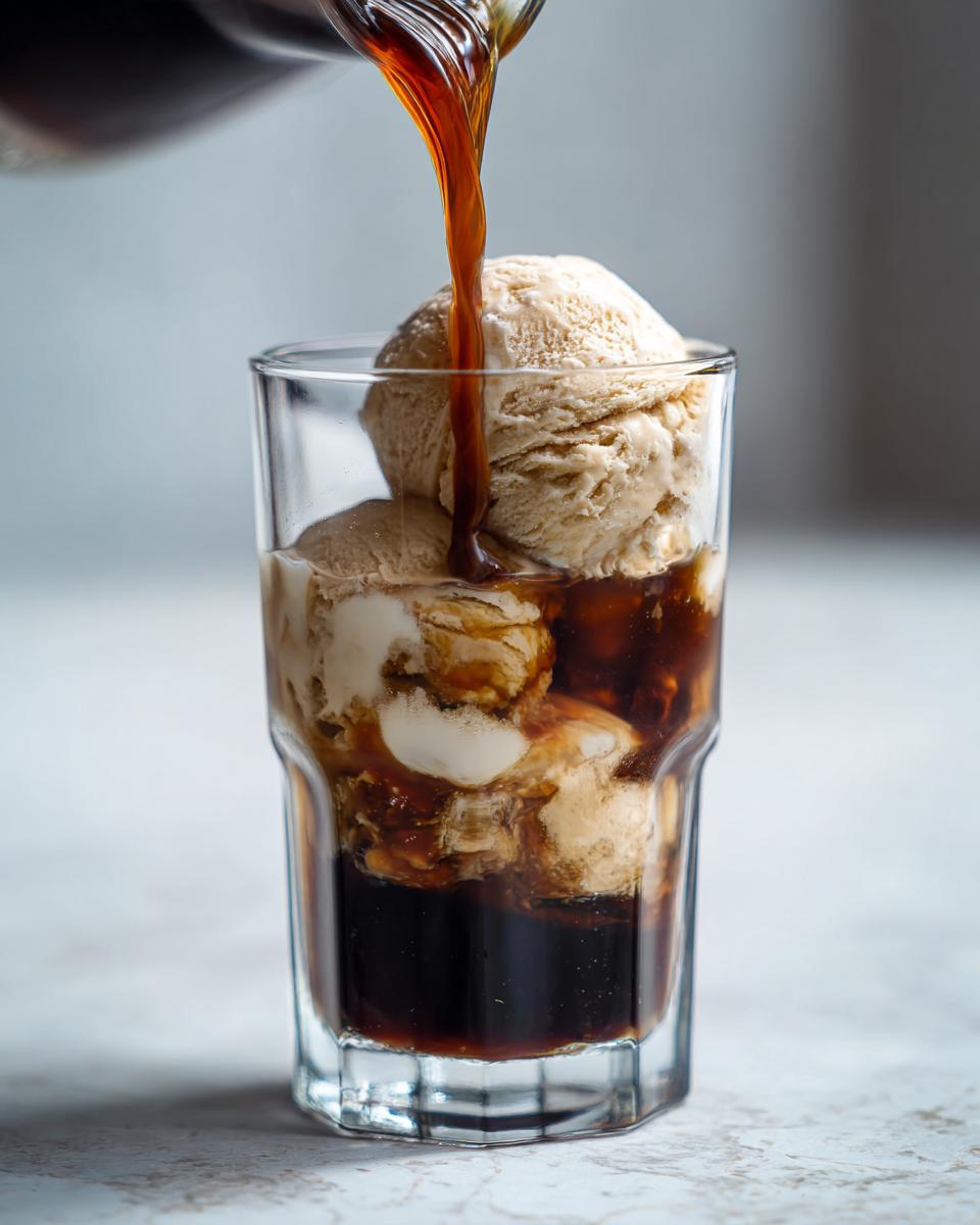 Cold brew being poured over ice cream in a glass, creating a delicious Cold Brew Affogato.