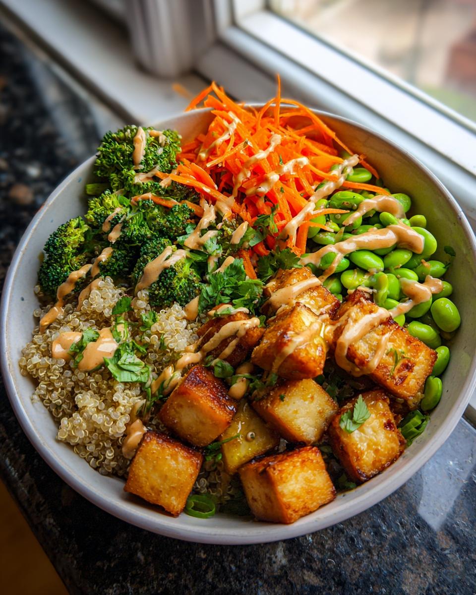 A vibrant Crispy Tofu Buddha Bowl with quinoa, broccoli, carrots, edamame, and crispy tofu.