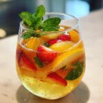 Close-up of a refreshing fruity cocktail with strawberries, oranges, and mint, a perfect 20 Refreshing Fruity Cocktails.