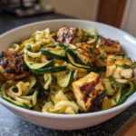 A bowl of grilled halloumi and zucchini pasta salad, a healthy and flavorful dish.