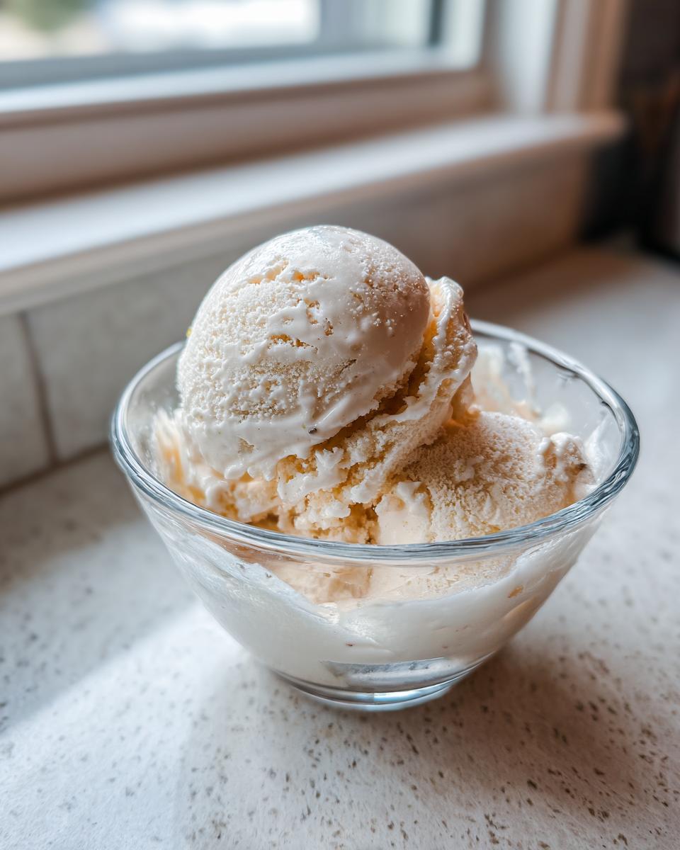 Scoops of Honey Lavender Ice Cream in a glass bowl, ready to enjoy.