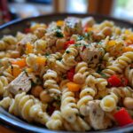 Close-up of a pasta salad protein bowl with chicken, chickpeas, and bell peppers.