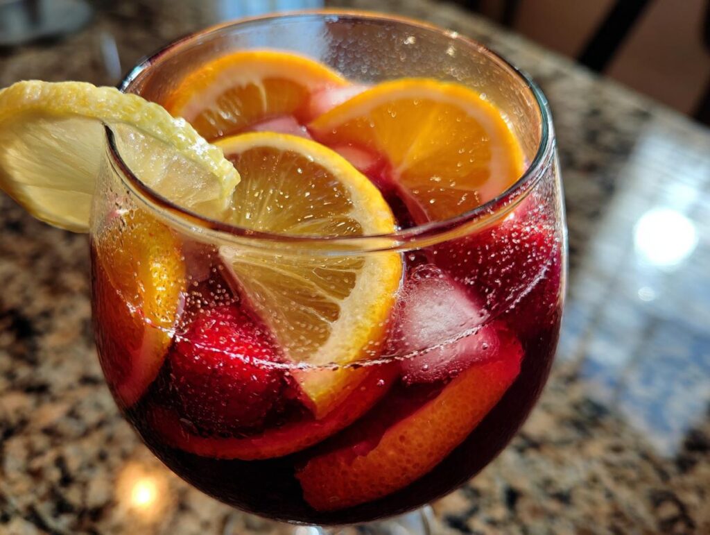 Close-up of a glass of refreshing Summer Sangria with orange and lemon slices.