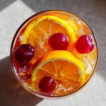 Overhead shot of a Vodka Party Punch cocktail with orange slices, cherries, and ice.